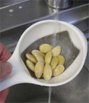 rinsing the blanched almonds under cold water
