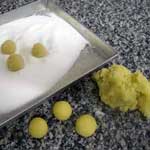 rolling almond paste cookies in sugar
