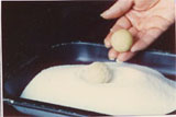 rolling the amaretti in sugar before baking