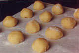 raw amaretti on a baking tray