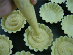 filling the lined pans with almond mixture