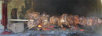 suckling pig roasting on the spit fire